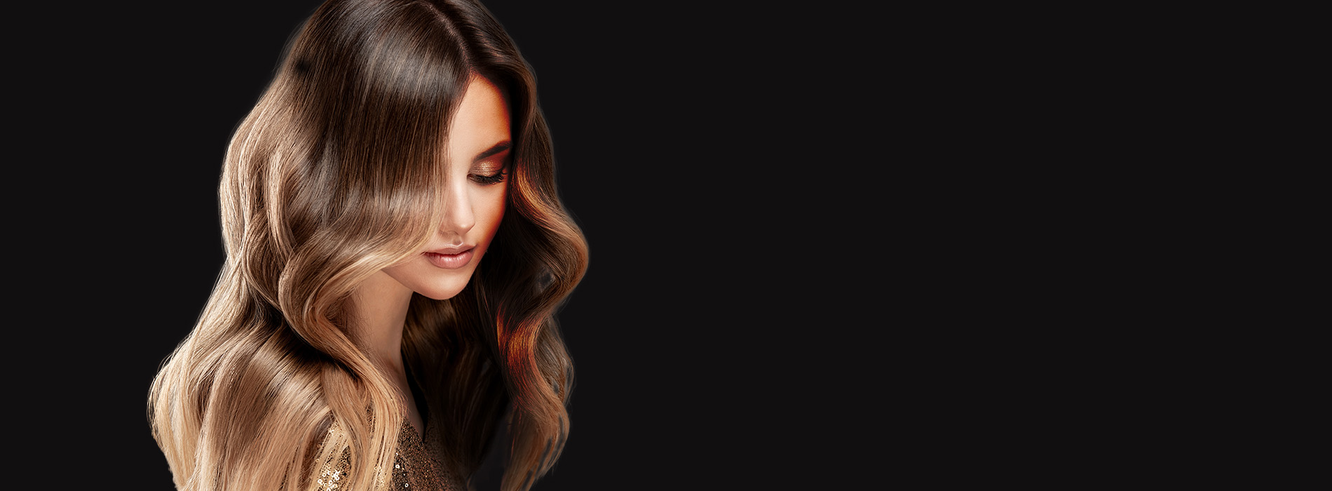 The image features a woman with long, wavy hair, wearing makeup and a dark outfit, standing against a black background.